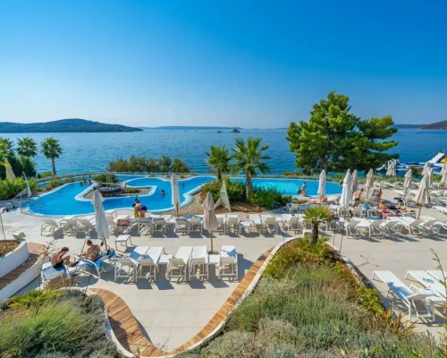 Schwimmbad und Liegestühle mit Blick auf das Meer auf dem Campingplatz Roan Amadria Park Trogir.